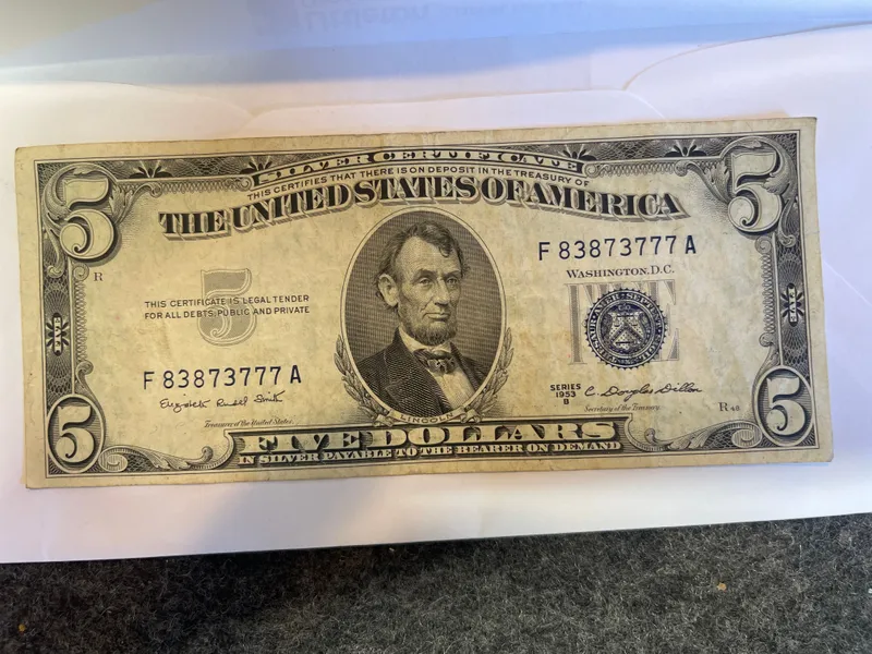 1953 B $5 Five Dollar Silver Certificate Blue Seal Note
The 1953 B $5 Five Dollar Silver Certificate Blue Seal Note is a circulated banknote from the United States. This small size note features a blue seal and is uncertified, making it a valuable addition to any coin and paper money collection. With its iconic design and historical significance, this silver certificate captures a moment in American currency history. from auction in Brewton, Alabama