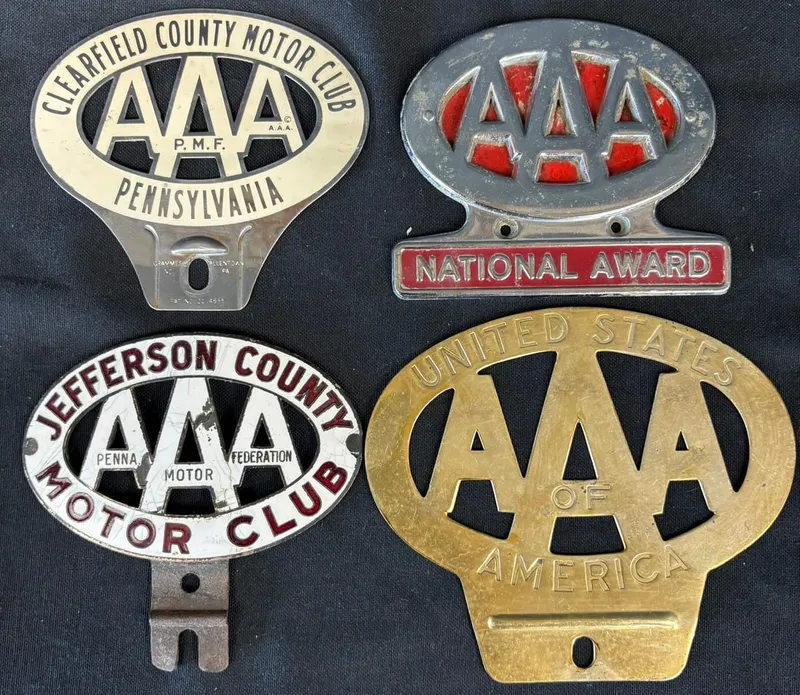 Lot 4 Porcelain & Stamped Metal AAA License Plate Toppers from auction in Jackson, Michigan