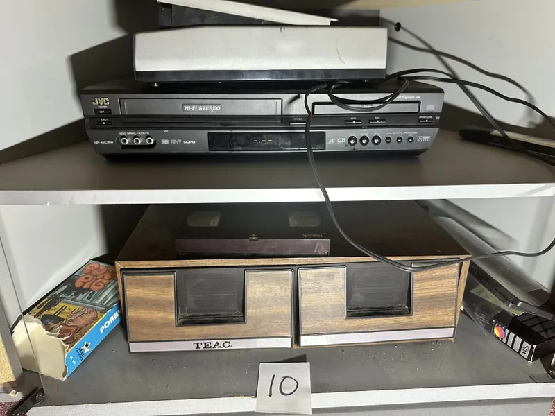 JVC VCR/DVD combo with Tape rewinder and assorted media on sheves from auction in Clifford , Pennsylvania