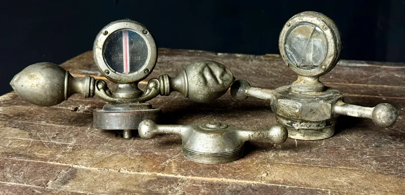 A Trio of Vintage Boyce Moto-Meter Radiator Caps and Temperature Gauges from auction in Campbell, New York